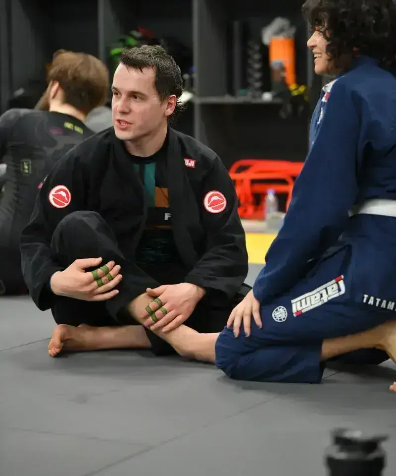 BJJ coach reviewing details with adult athletes after training