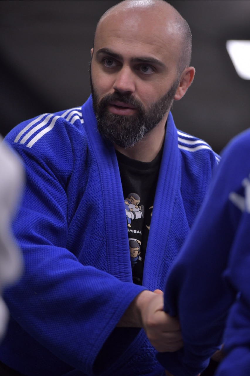 Judo coach demonstrating stand-up technique for grapplers