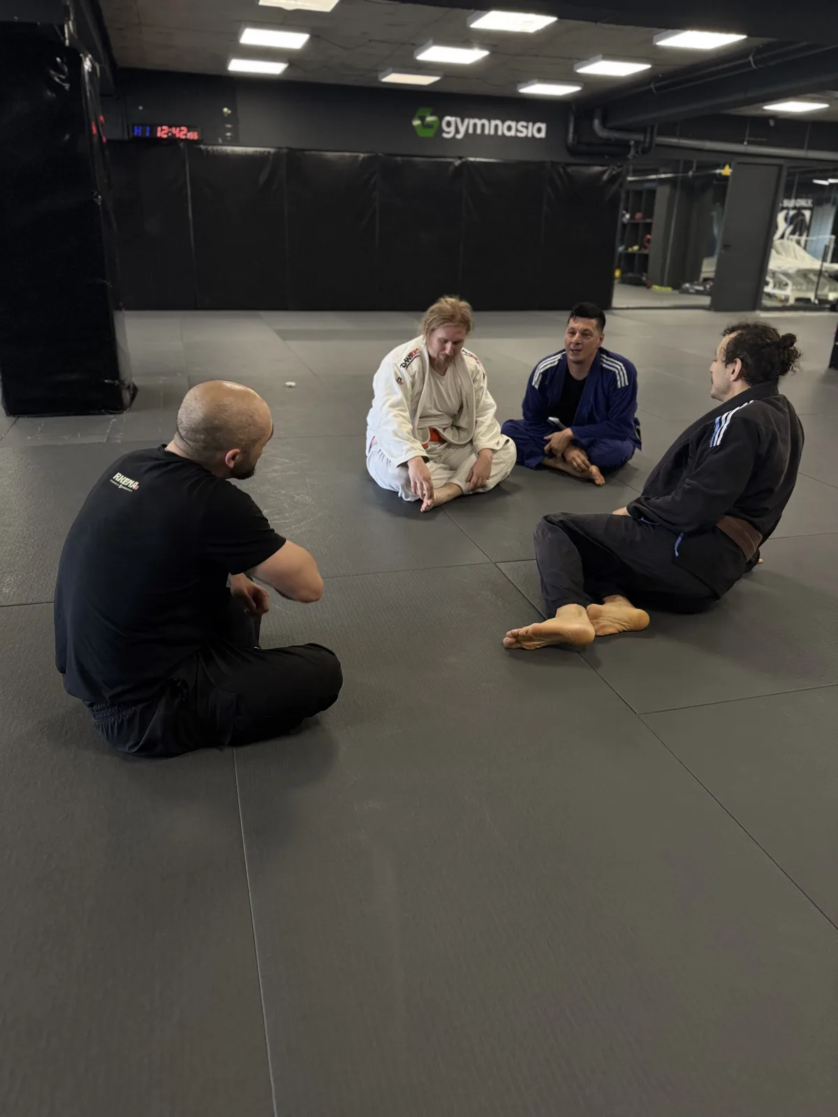 Archive photo of a coach talking through a technique with students in gi